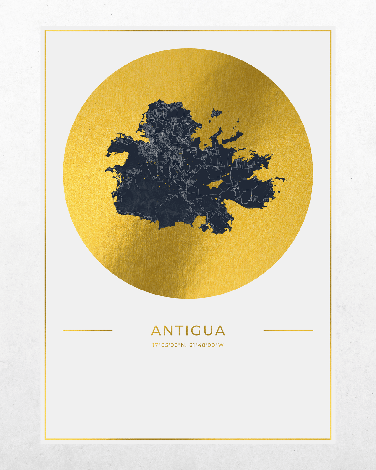 A minimalist travel poster of Antigua featuring a dark navy blue map silhouette centered inside a large textured gold circle, with the word 'ANTIGUA' and coordinates printed below on a white background with a thin gold border.