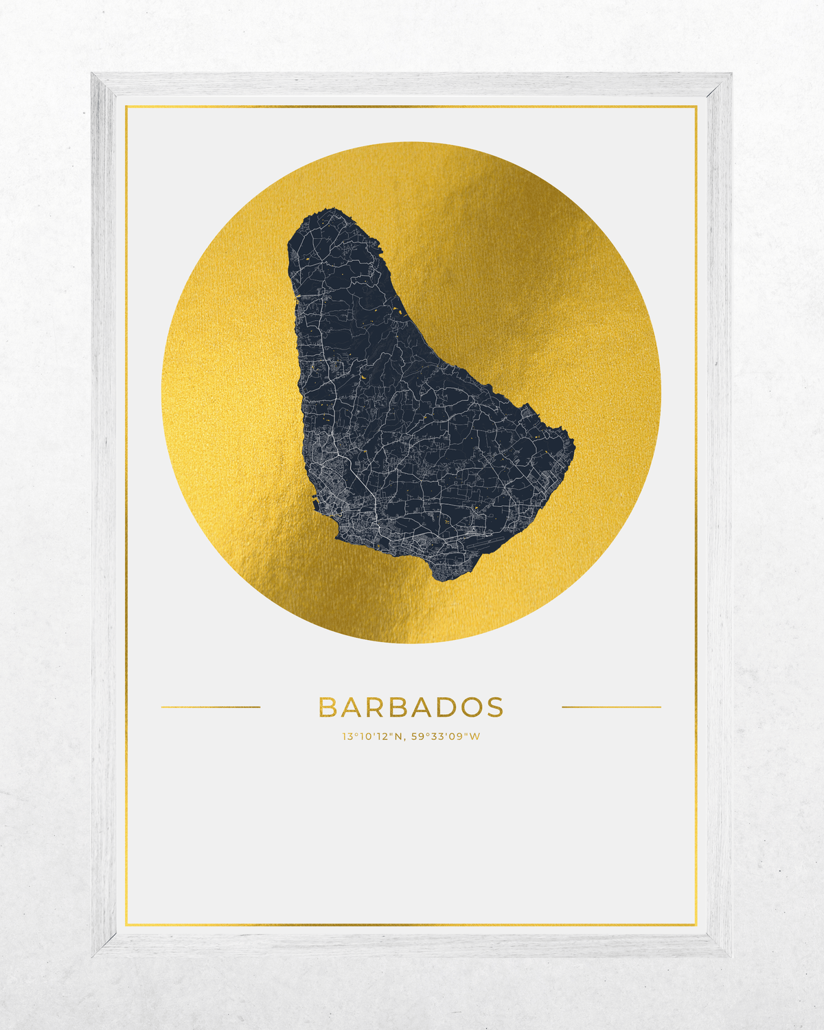 Framed Barbados map art print with a dark navy blue map silhouette centered inside a large metallic gold circle on a white background, with the word BARBADOES and coordinates below. The print is housed in a white textured frame.