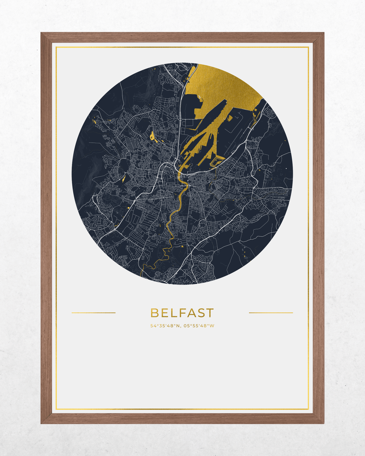 Framed circular Belfast city map wall art with a dark navy map design, gold highlighted areas and text, and a light wood frame on a white wall.