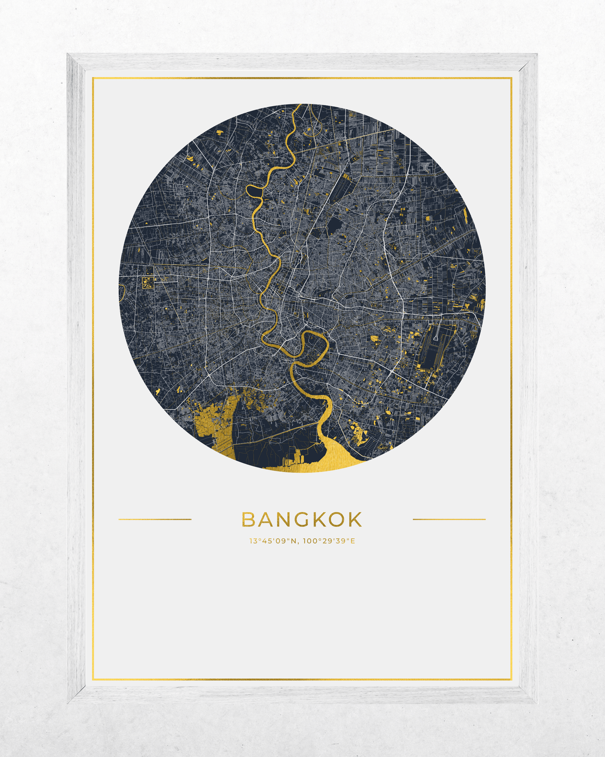 A framed circular map print of Bangkok, featuring a dark navy street grid with bright gold river lines and city highlights, plus the word BANGKOK and coordinates below, shown in a white frame against a light textured background.