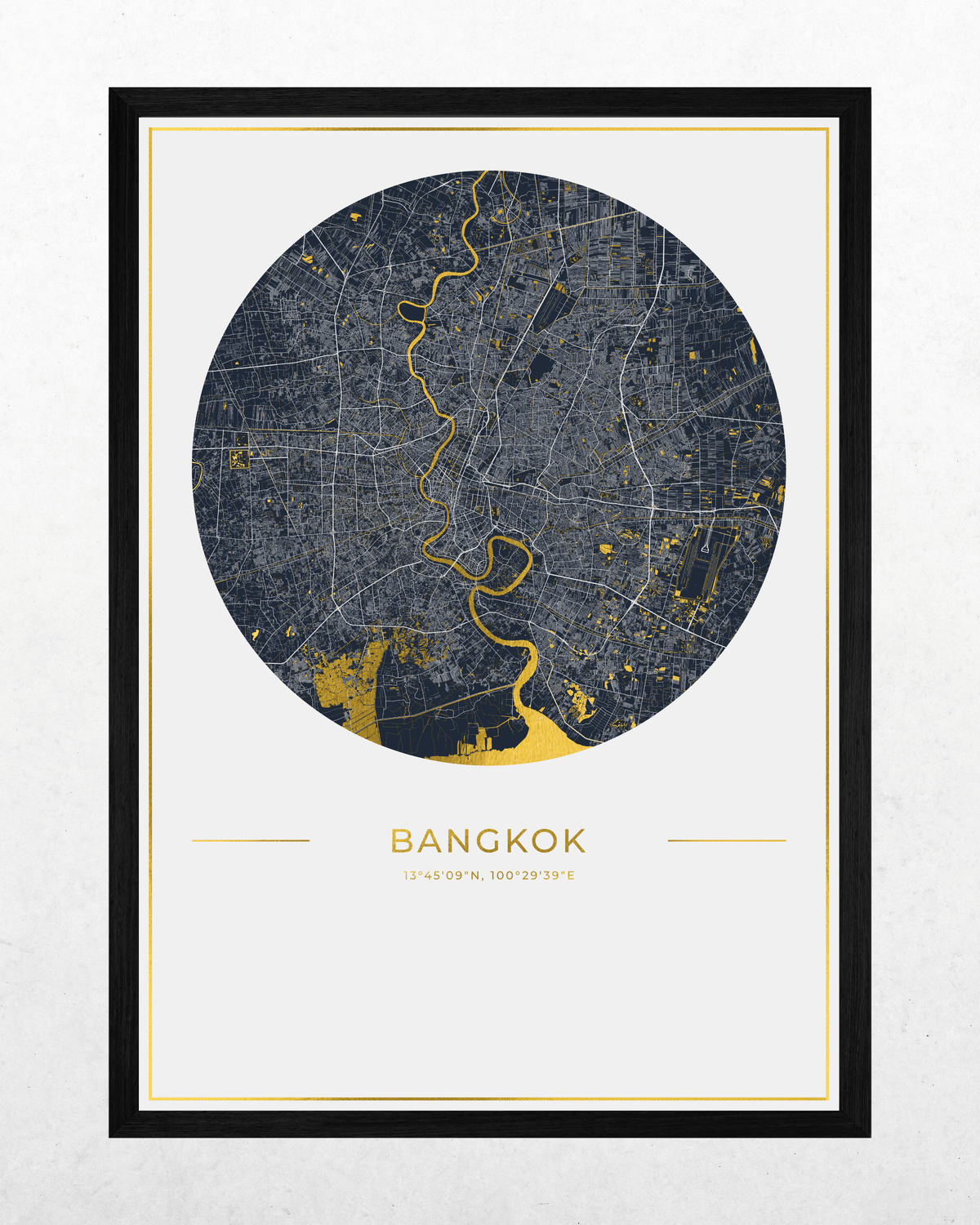 A framed circular map print of Bangkok, featuring a dark gray street grid with bright yellow gold and the city name printed below, shown against a light textured background.