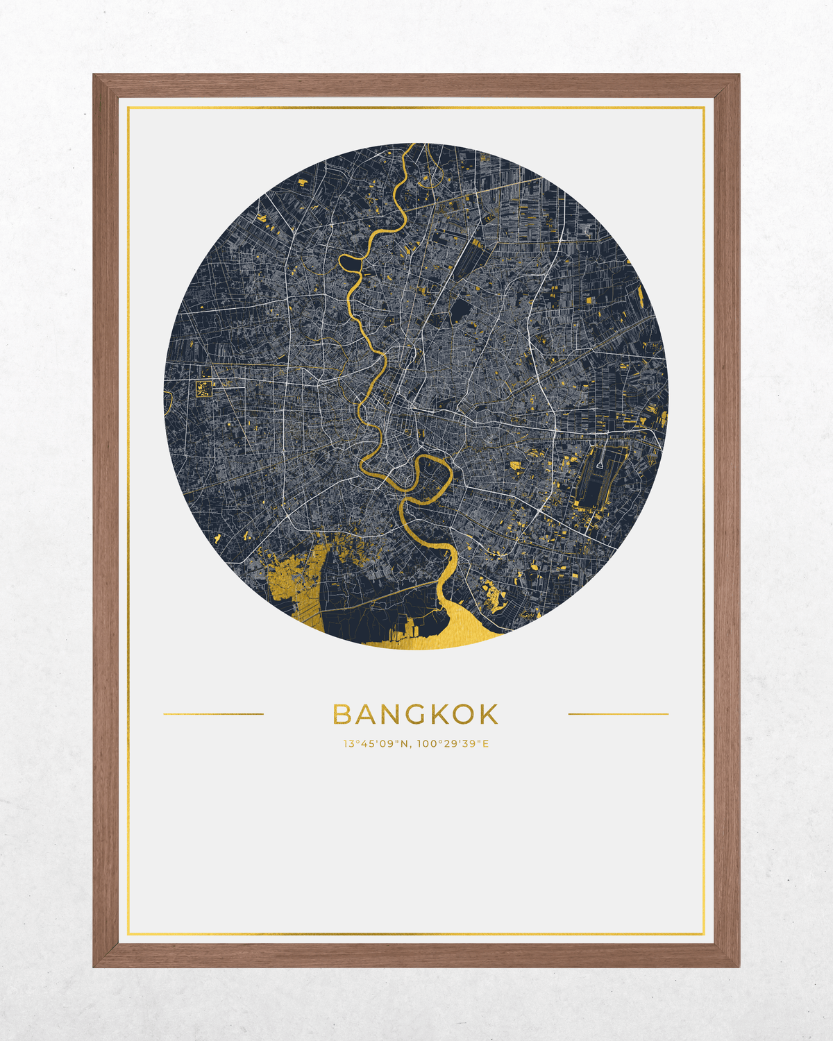 A framed circular map print of Bangkok, Thailand, featuring a dark gray street layout with gold highlights and the city name printed below, shown in a brown wood frame against a white wall.