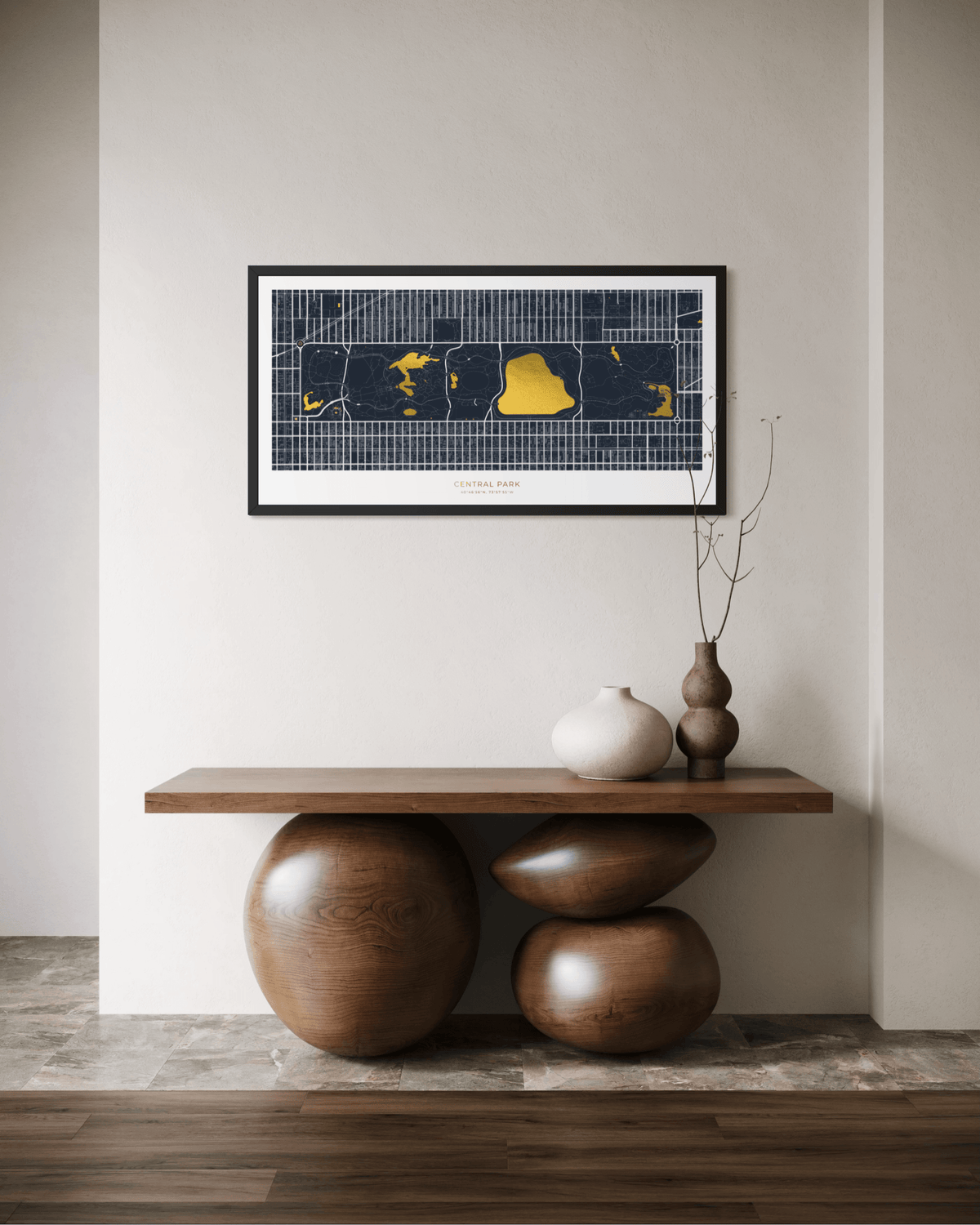 A framed New York City street map art print hangs on a light beige wall above a wooden console table with sculptural wooden bases and decorative vases.