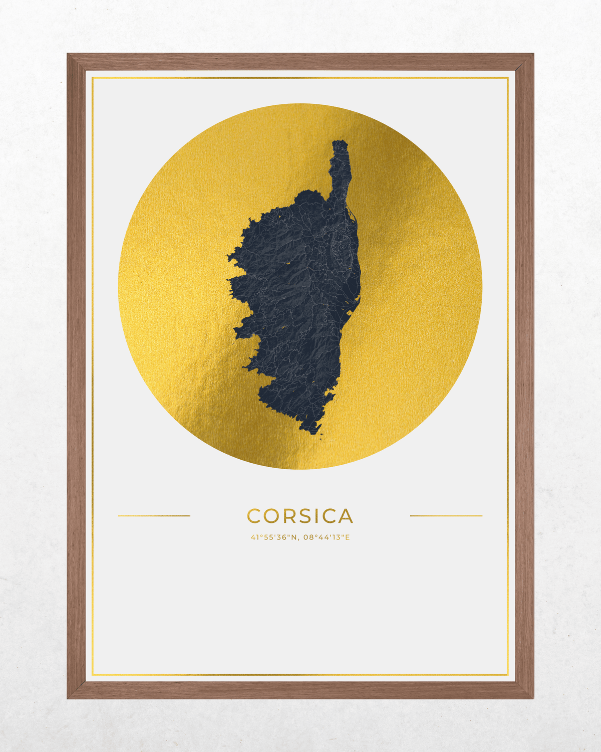 Framed wall art featuring a textured dark navy map silhouette of Corsica centered within a large metallic gold circle, with the word 'CORSICA' and small coordinates below on an off-white field, all enclosed in a brown wood frame.