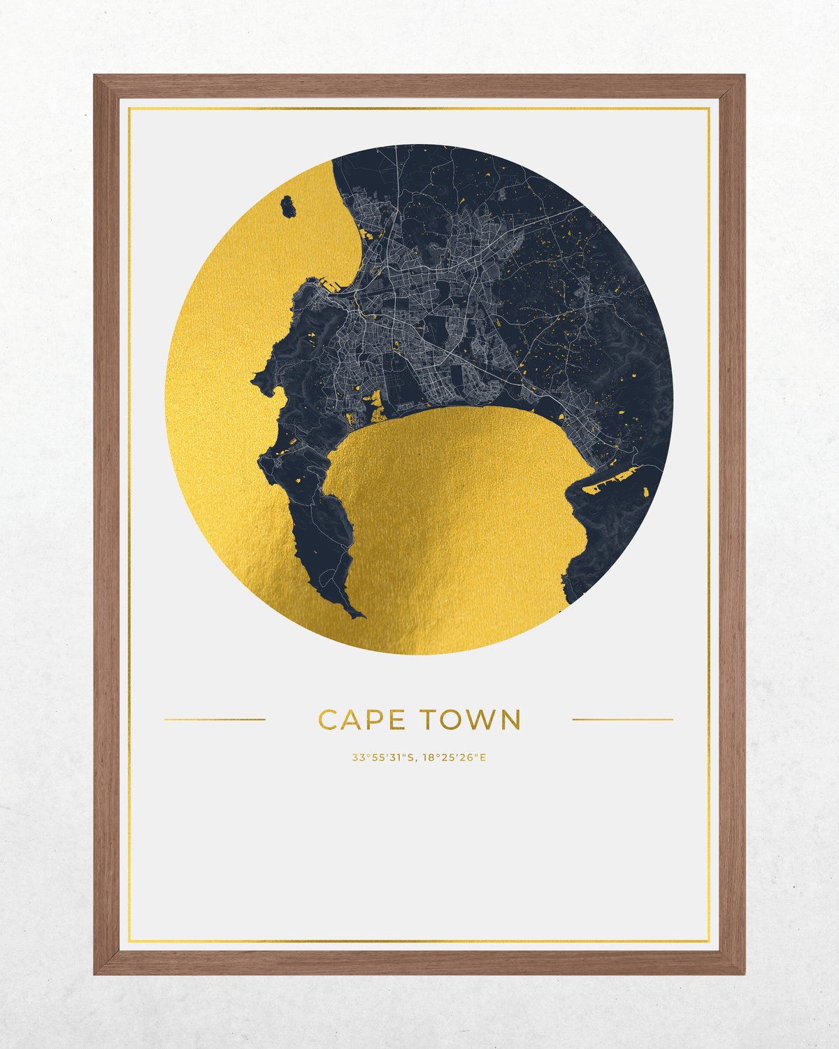 Framed wall art print featuring a stylized map of Cape Town, with a large gold circle over a dark navy landmass and the text 'CAPE TOWN' below, shown in a brown wood frame against a light textured wall.