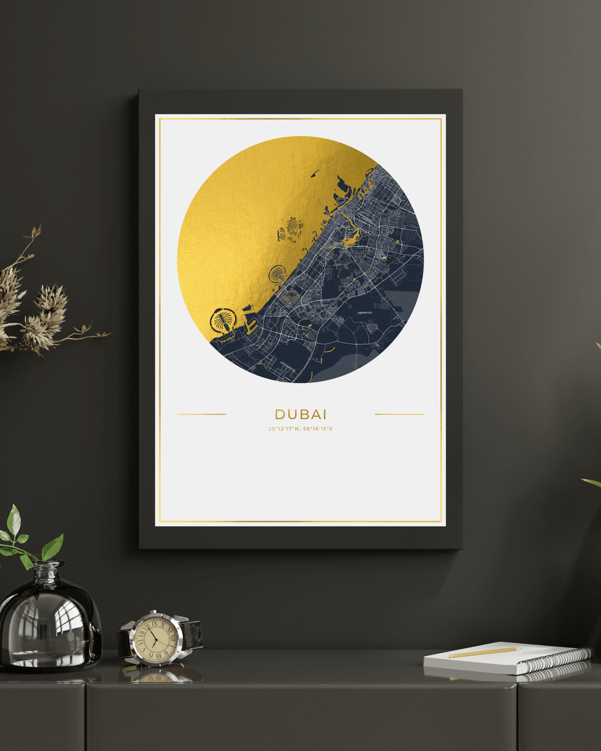 A framed art print of a Dubai street map, featuring a circular design in gold and navy blue on a white background, hanging on a dark gray wall above a console table with decorative items.