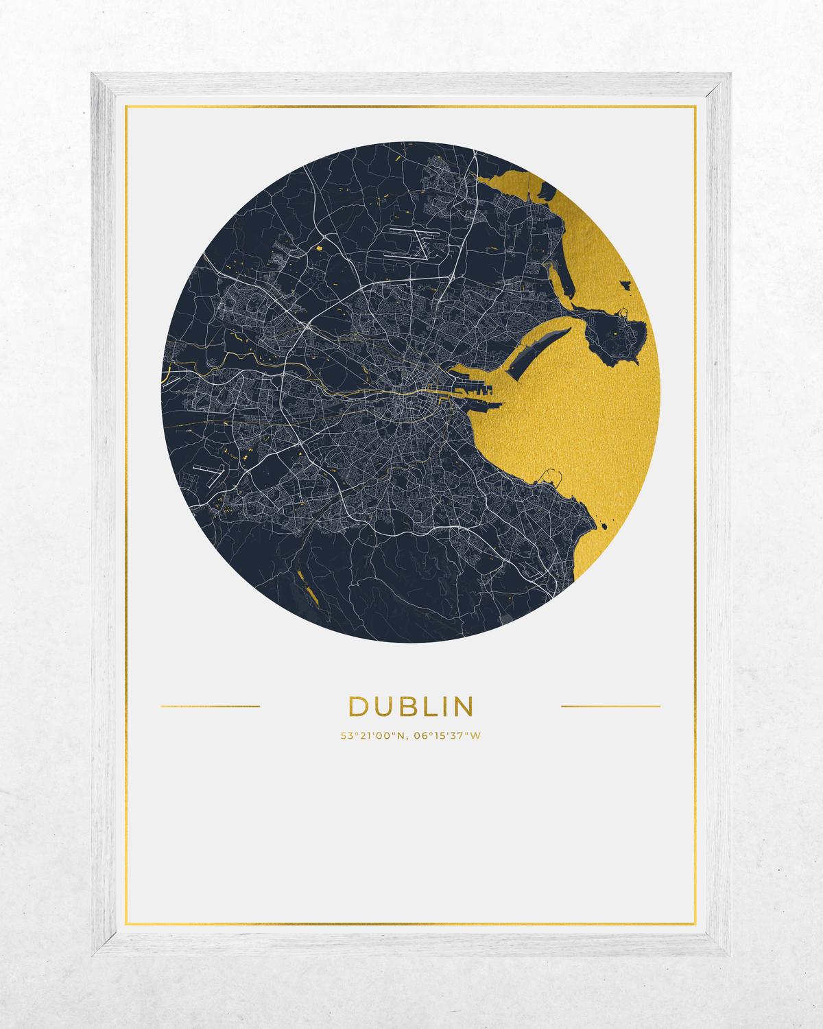 A framed city map print of Dublin, Ireland, featuring a circular navy and gold map design with the city name and coordinates printed below, set in a white frame against a light textured background.