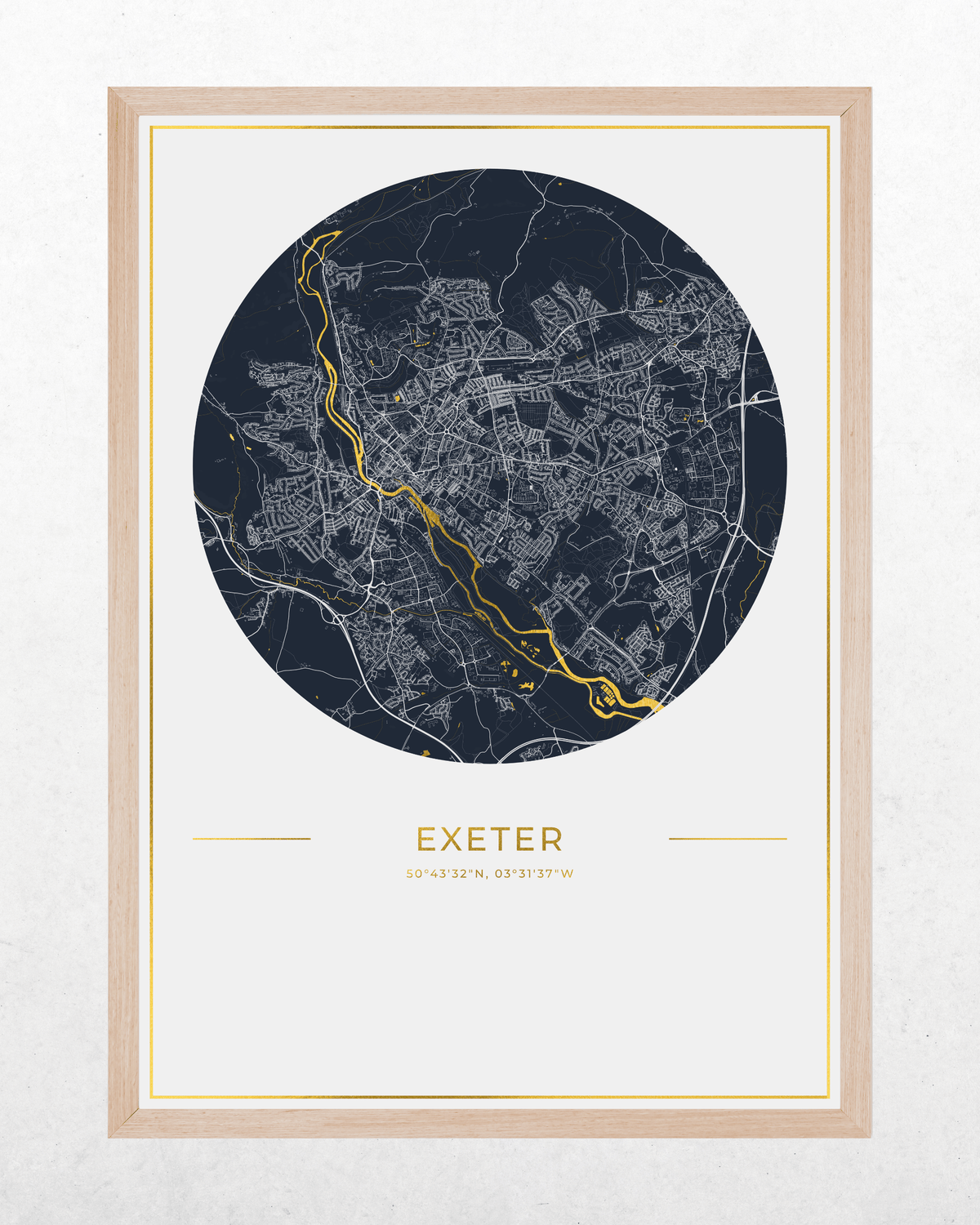 A framed circular city map print of Exeter, featuring a dark navy blue map with white street details and a highlighted gold river running through the center, set in a light wood frame against a textured off-white background.