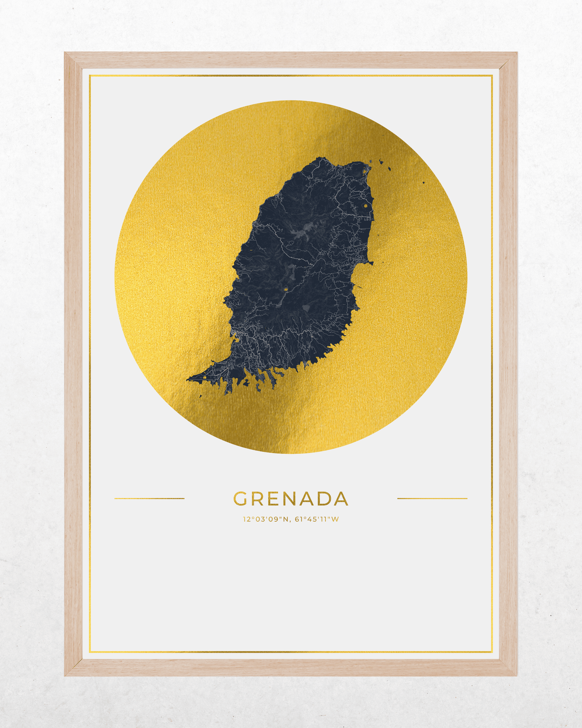 A framed art print featuring a stylized map of Grenada in dark navy blue, set against a large textured gold circular backdrop. The print is housed in a light natural wood frame and is displayed on a clean, light-textured wall.