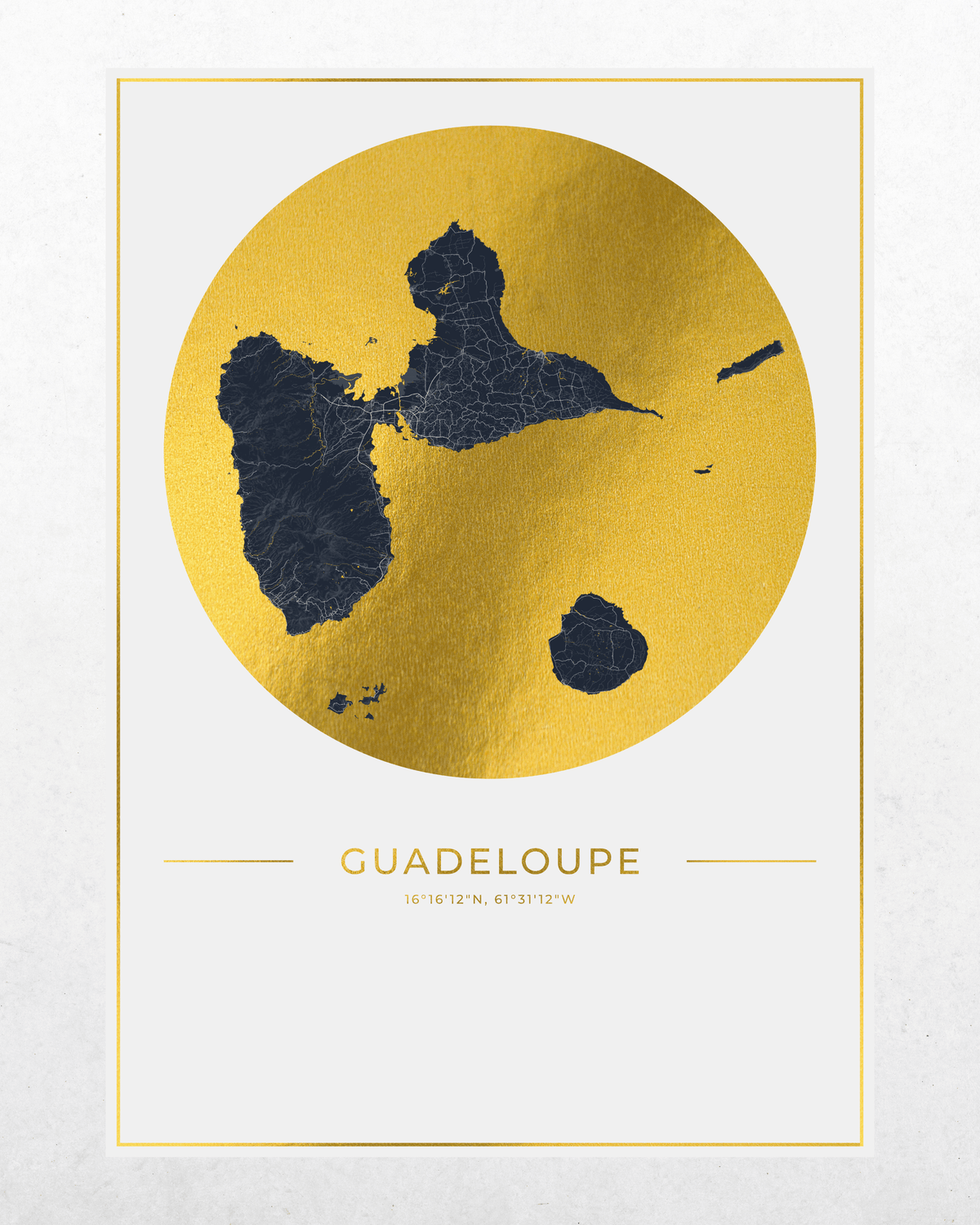 A minimalist travel poster of Guadeloupe, featuring a gold foil map of the island with dark blue accents, framed by a thin gold border on a textured off-white background.