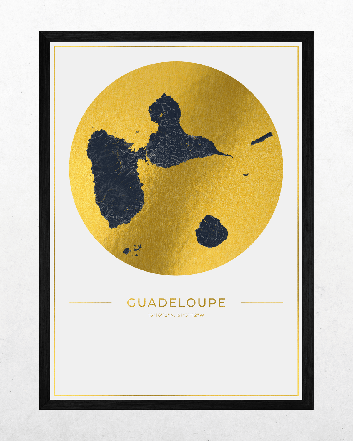 A framed map art print of Guadeloupe, featuring a gold foil circle with the island silhouette in dark navy blue, set against a white background with the name 'GUADELOUPE' printed below.