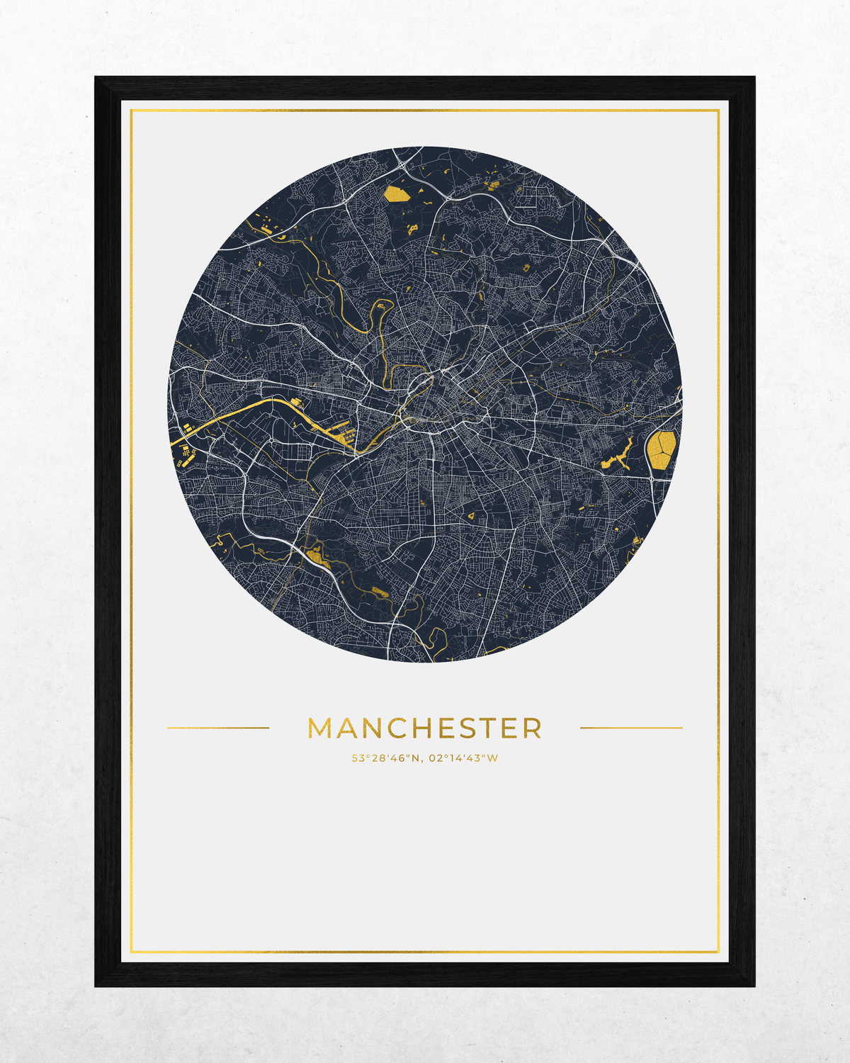 A framed city map print of Manchester, UK, featuring a dark navy circular map with light gray street lines and bright gold highlights, set against a white background with a black frame and gold inner border.