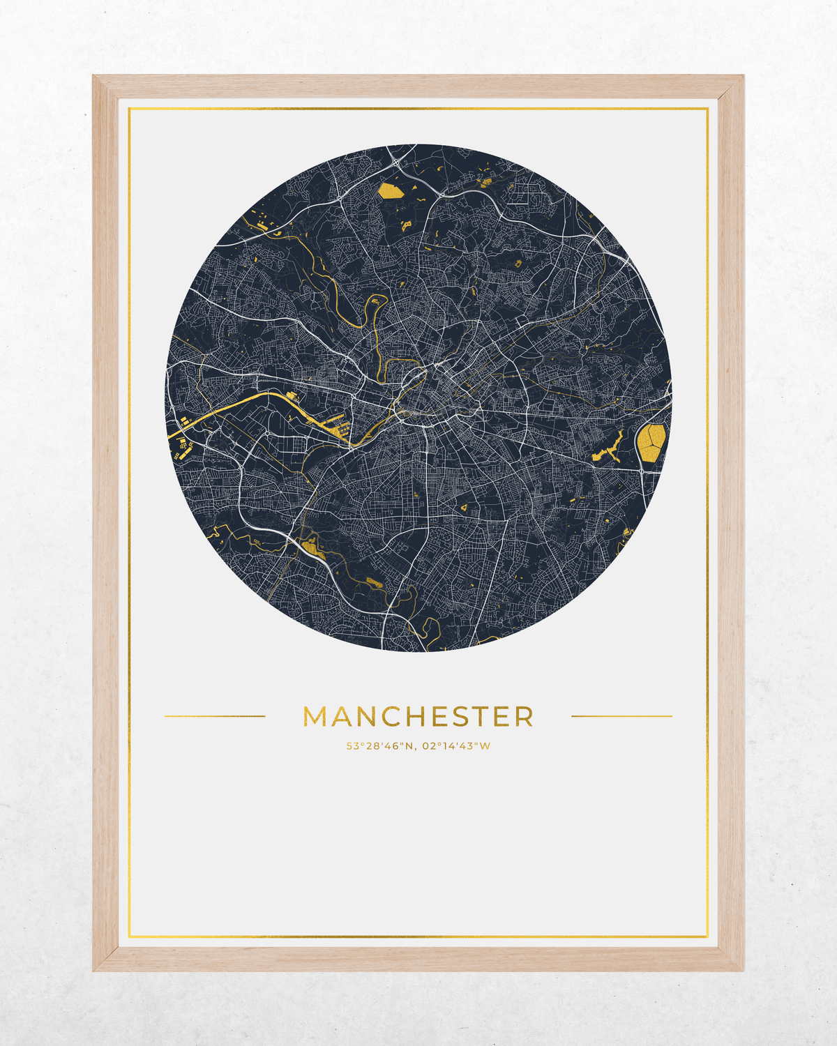 A framed circular city map print of Manchester, UK, featuring a dark navy street network with bright gold highlights on an off-white background, enclosed in a light natural wood frame.