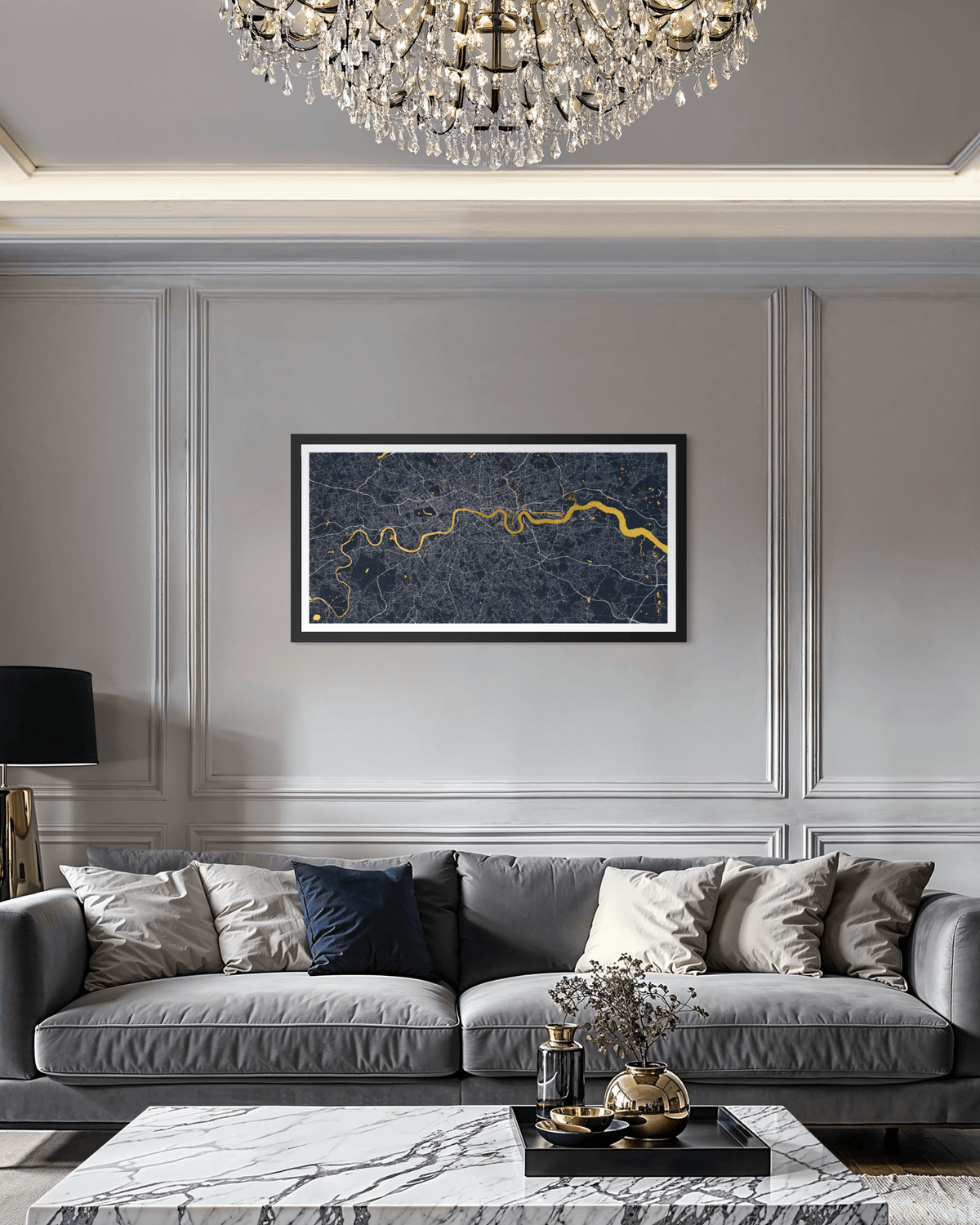 A framed horizontal art print featuring a dark navy blue and gold map of London, displayed on a gray paneled wall above a gray sofa in a modern living room setting.