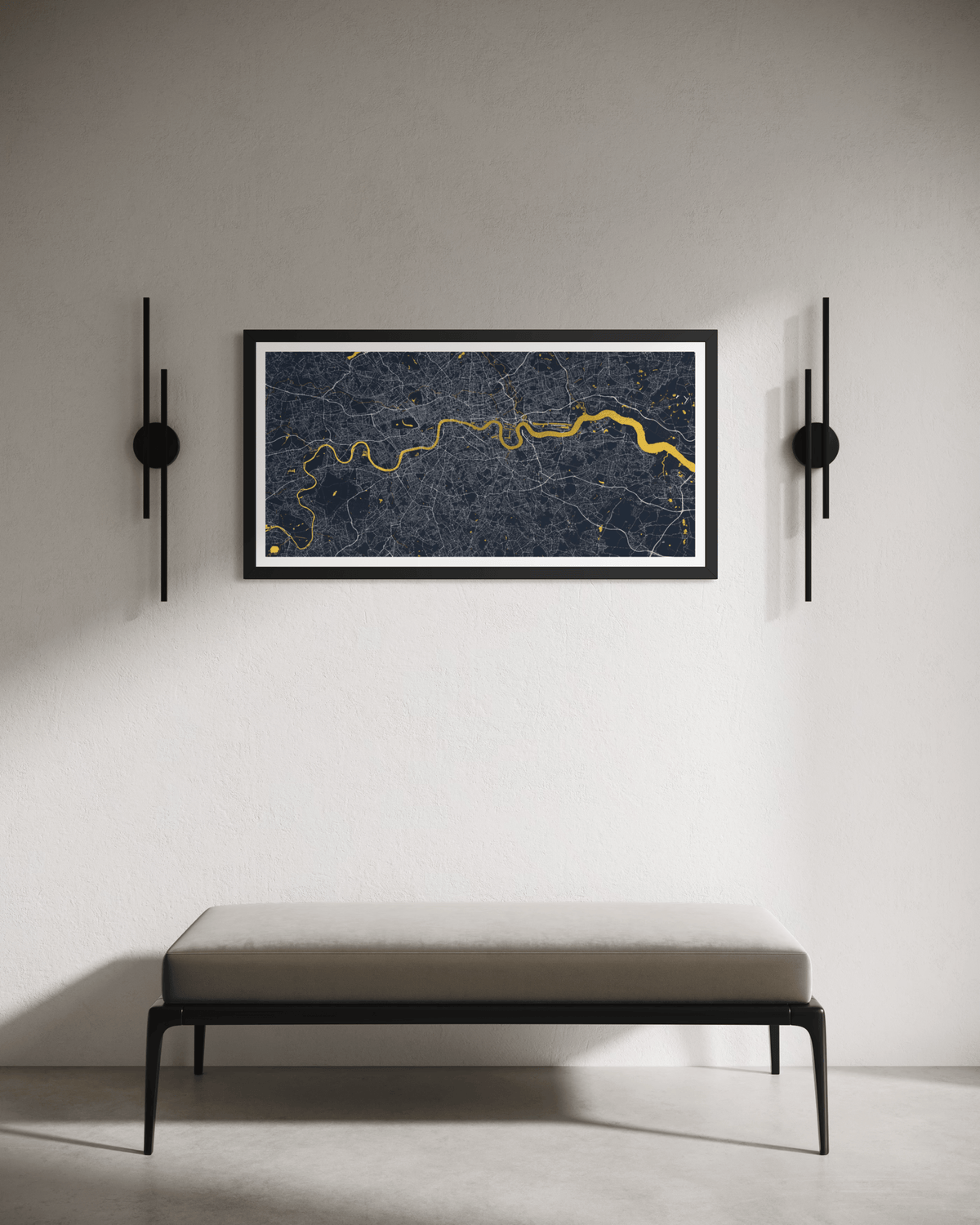 A framed art print of a dark blue and gold London map hangs on a light gray wall above a minimalist bench, flanked by two black wall sconces.