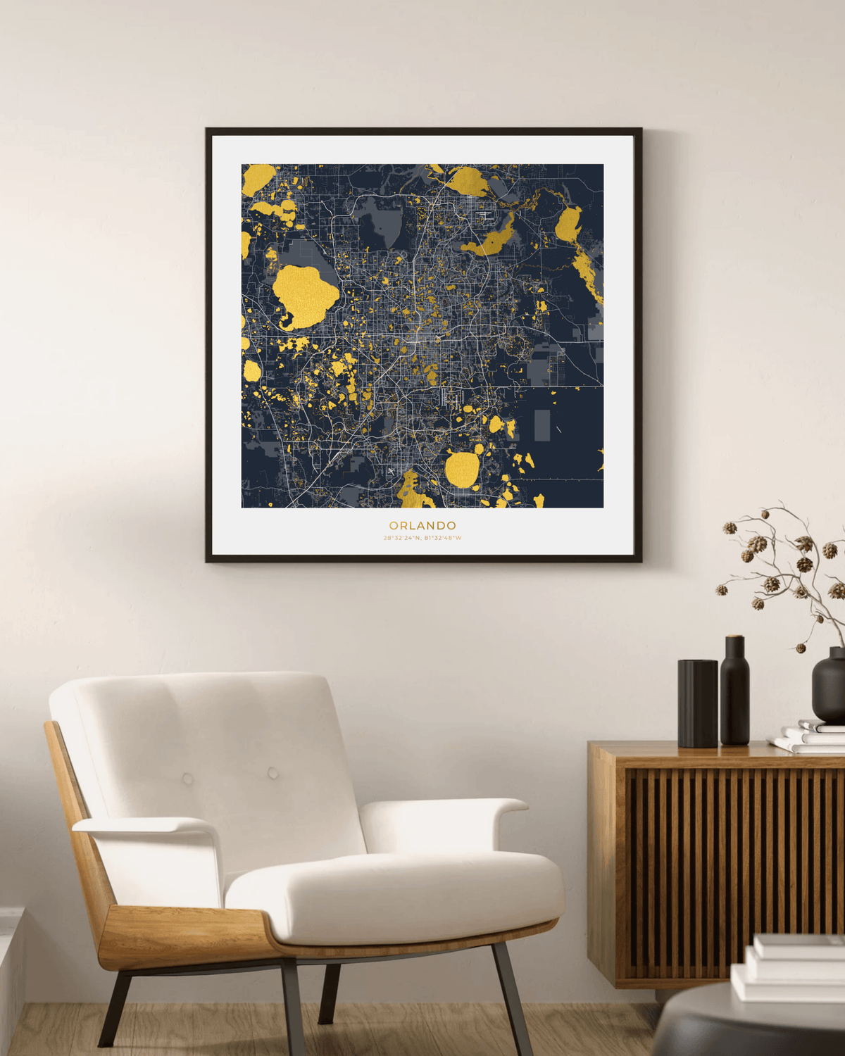 A framed city map print of Orlando in navy blue and gold, displayed on a beige wall above a white armchair and a wooden sideboard in a modern living room setting.