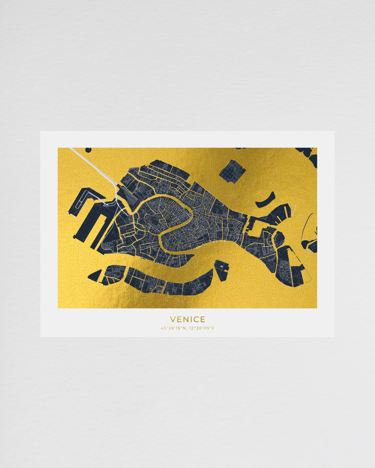 A minimalist map art print of Venice, featuring a dark navy blue street grid on a textured metallic gold background, presented on a white card with the word 'VENICE' printed below.