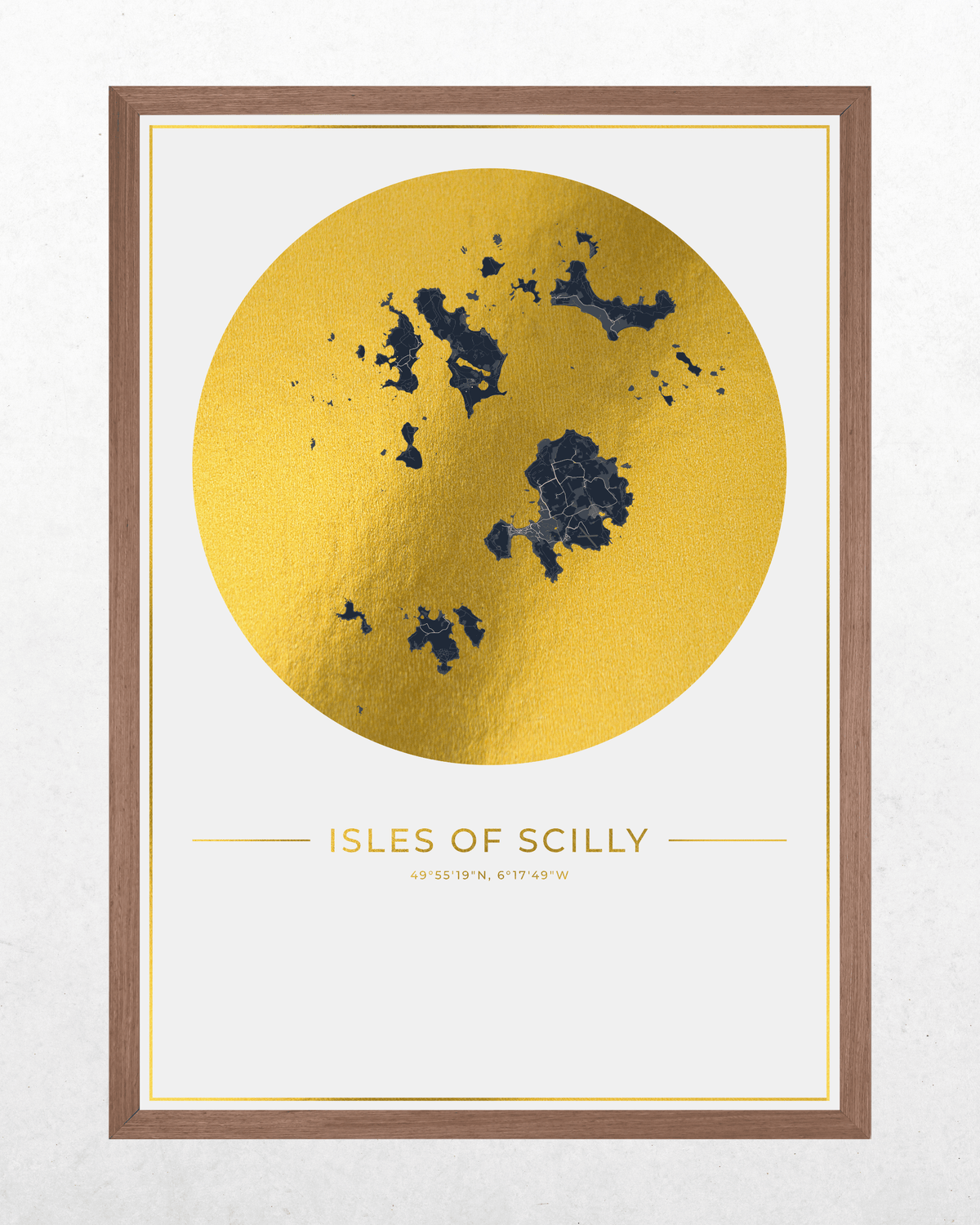 Framed wall art print featuring a large metallic gold circle with a dark blue map of the Isles of Scilly and the text 'ISLES OF SCILLY' below, shown in a brown wood frame against a light textured wall.