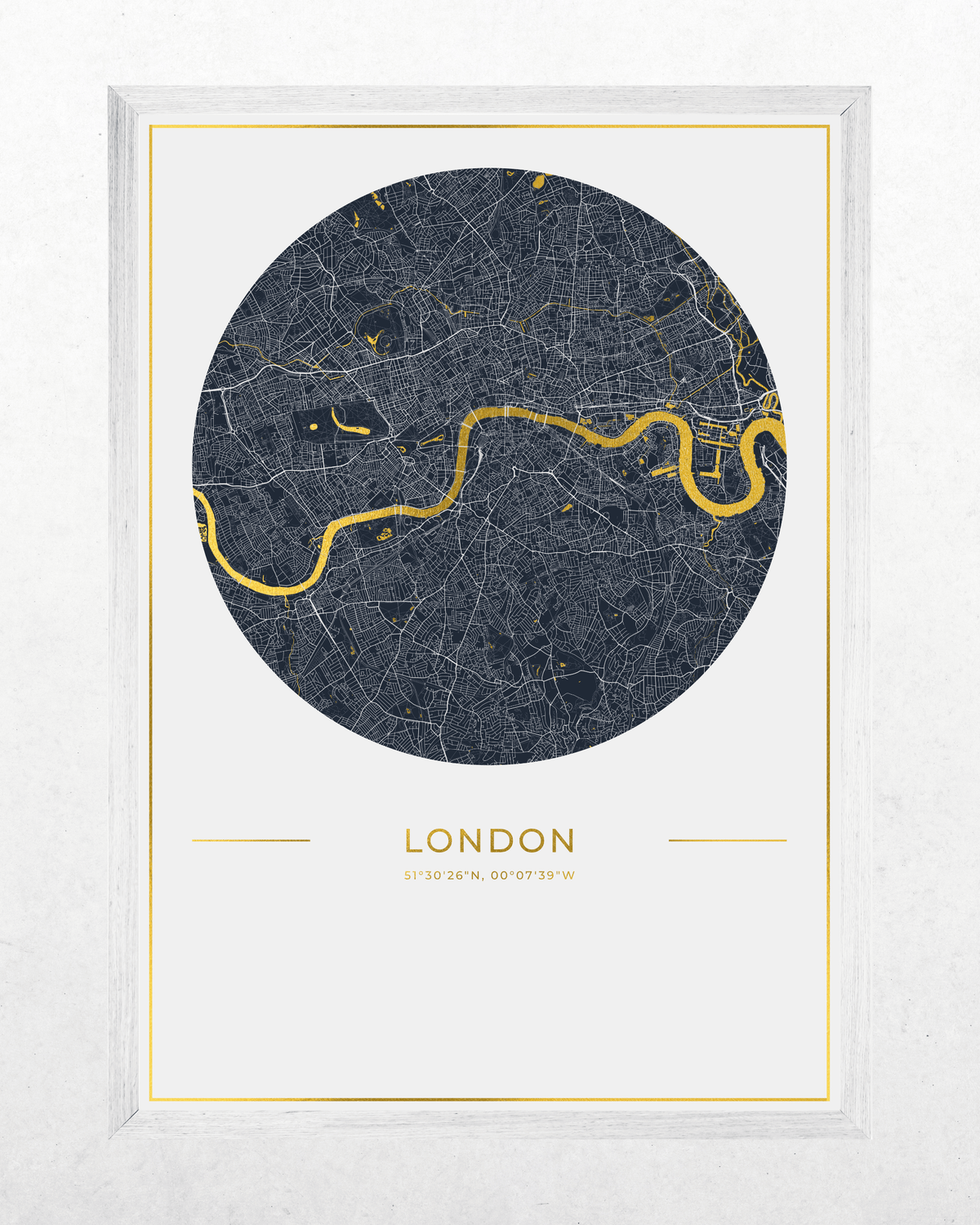 A framed circular London city map print with a dark navy street network, a bright gold river running through the center, and gold text reading 'LONDON' below, shown in a white frame against a light textured wall.