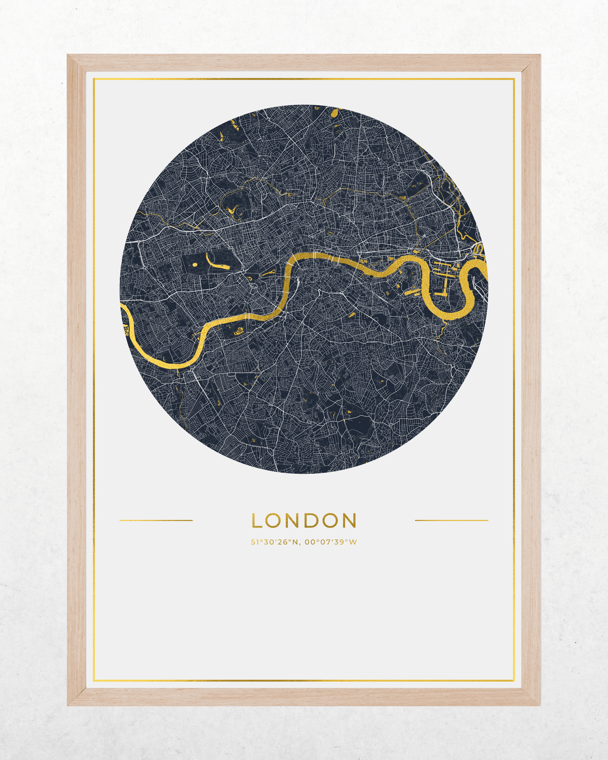 A framed circular London city map print with a dark navy street network, a bright gold river, and gold text reading 'LONDON' on a white background, set in a light wood frame.