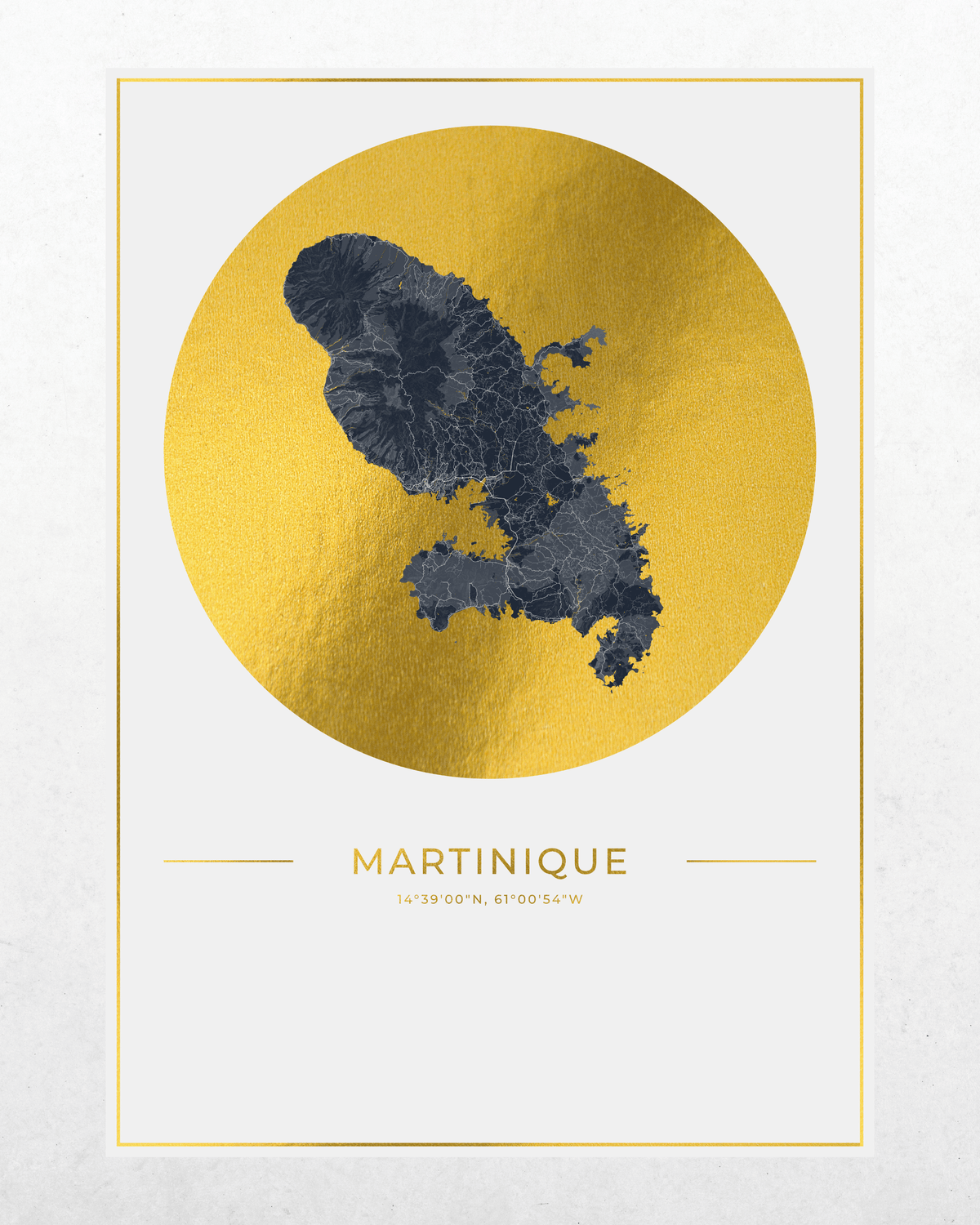 A minimalist art print of a map of Martinique, featuring a dark gray landmass silhouette centered inside a large textured gold circle, with the country name and coordinates printed below on a white background with a thin gold border.