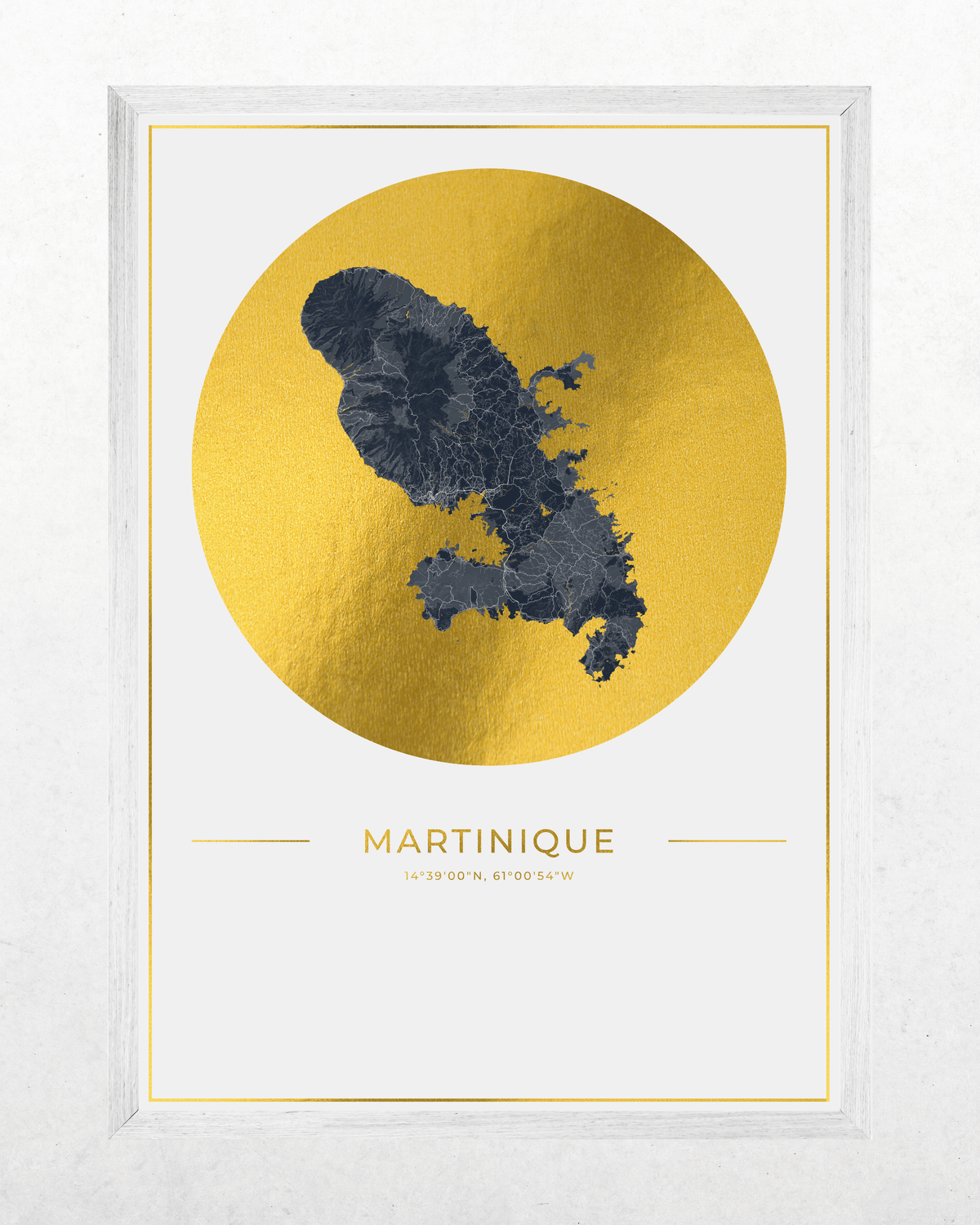 Framed wall art print featuring a dark blue map of Martinique over a large textured gold circle on a white background, with the word MARTINIQUE and small coordinates below. The print is housed in a white wood frame.