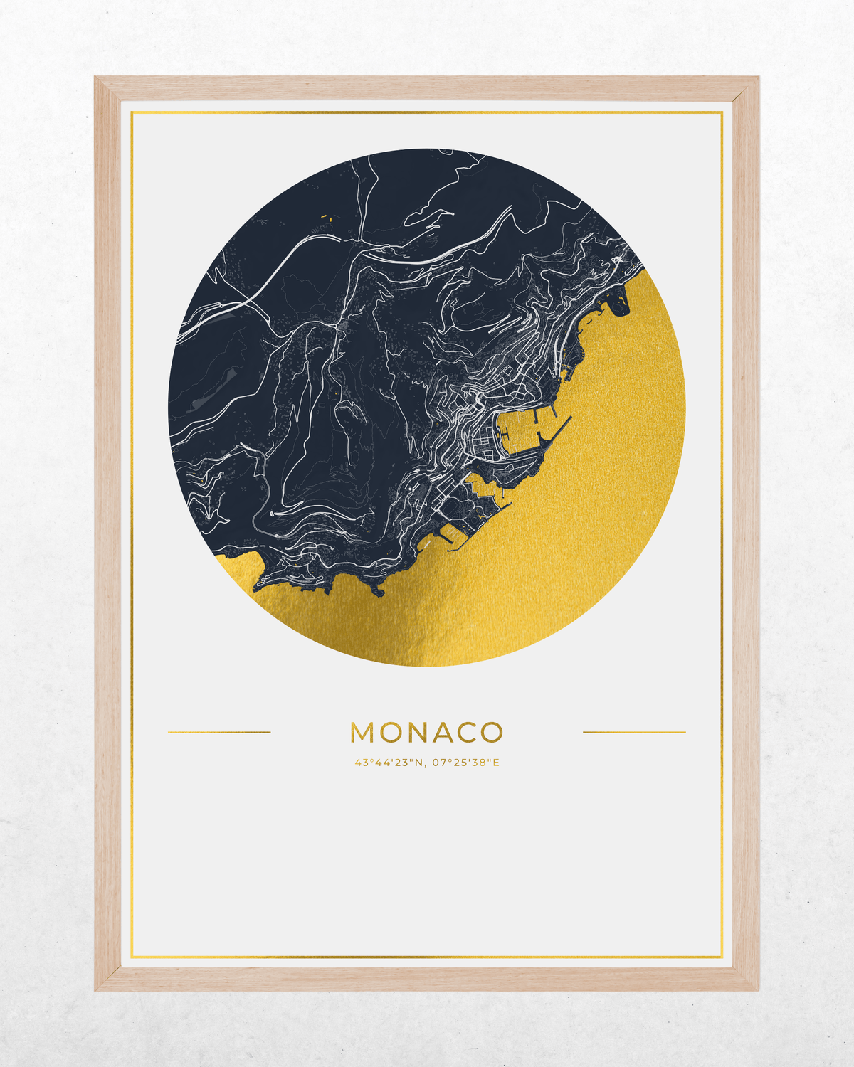 A framed art print featuring a stylized map of Monaco. The design shows a circular graphic with a dark navy blue top half and a textured gold bottom half, separated by a coastline line.