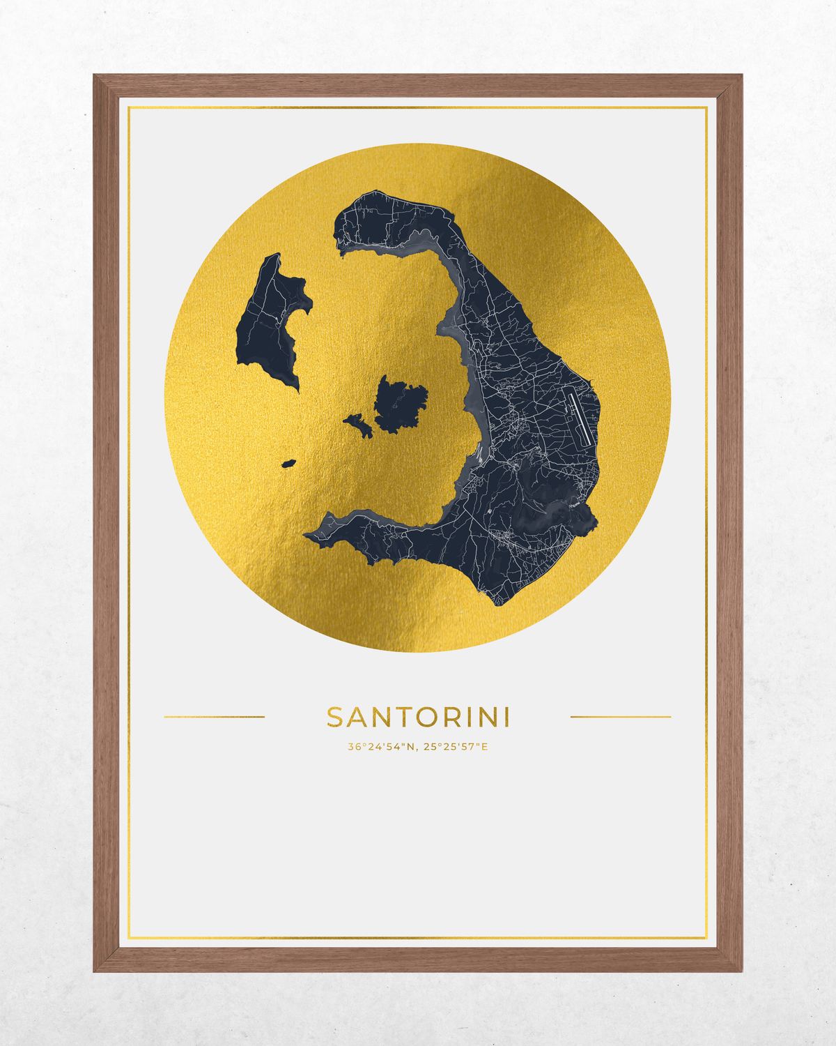 Framed wall art print featuring a stylized map of Santorini, Greece, with a dark navy blue island silhouette over a large metallic gold circle on a white background, with the text 'SANTORINI' and 'ICANOS, EGEEAN' below. The print is enclosed in a thin white mat and a warm brown wooden frame, shown against a light textured wall.