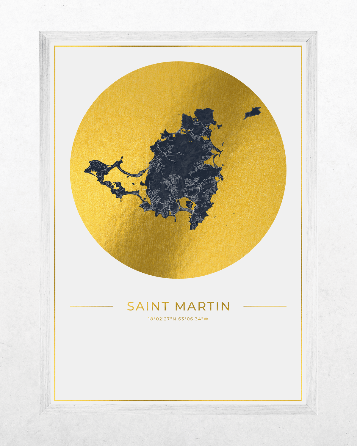 Framed wall art print featuring a dark navy map silhouette of Saint Martin inside a large metallic gold circle, with the text 'SAINT MARTIN' below on a white background. The print is housed in a white frame and photographed against a light textured wall.