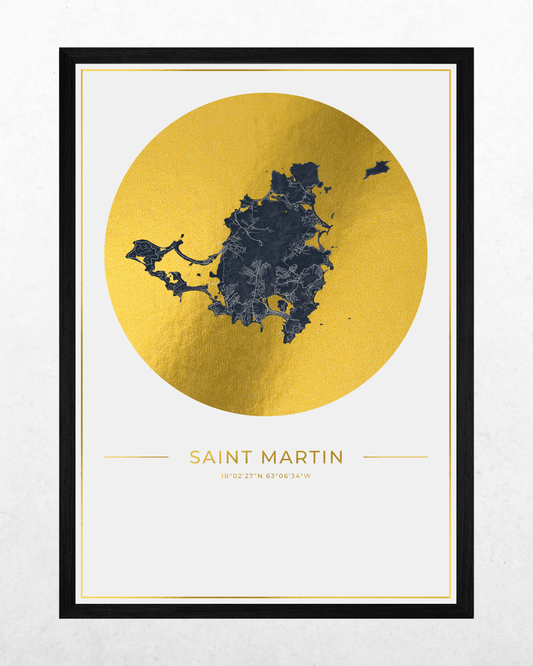 A framed minimalist map print of Saint Martin, featuring a dark navy blue map silhouette inside a large textured gold circle on a white background, with the text 'SAINT MARTIN' and coordinates below. The print is framed in a thin black frame.