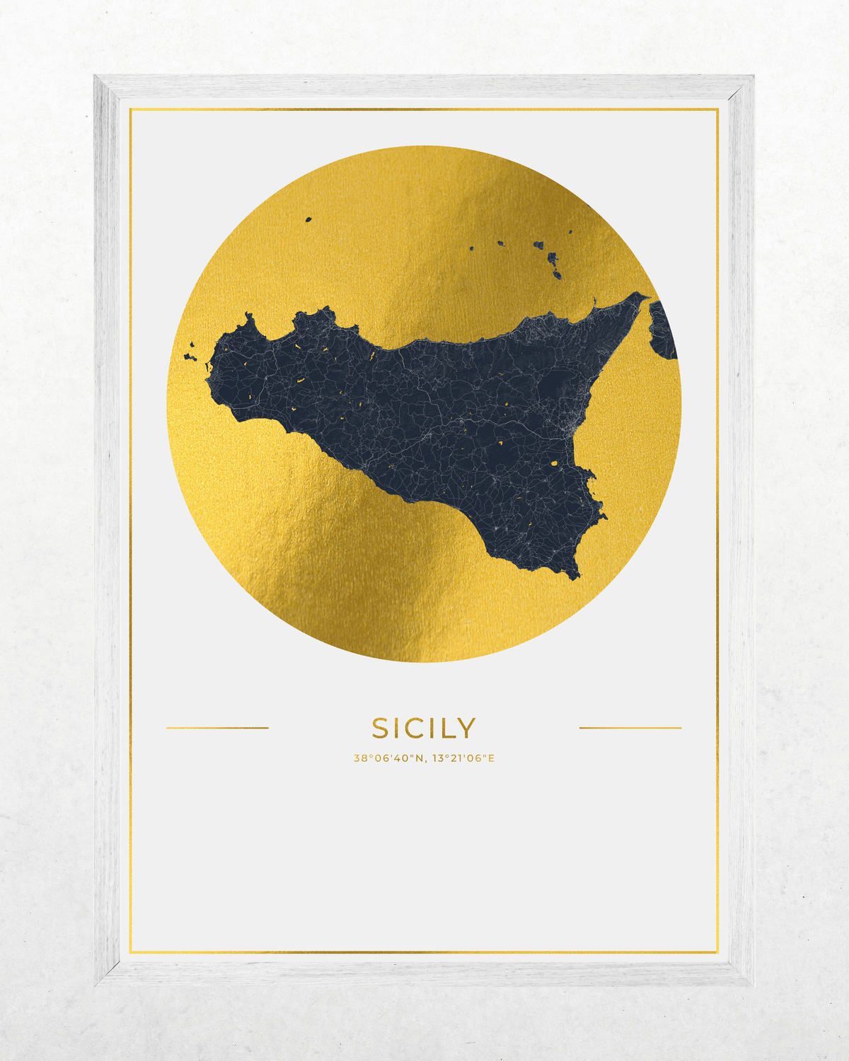 Framed wall art print featuring a stylized map of Sicily in dark navy blue inside a large metallic gold circle, with the word "SICILY" and coordinates below, shown in a white frame against a light textured background.