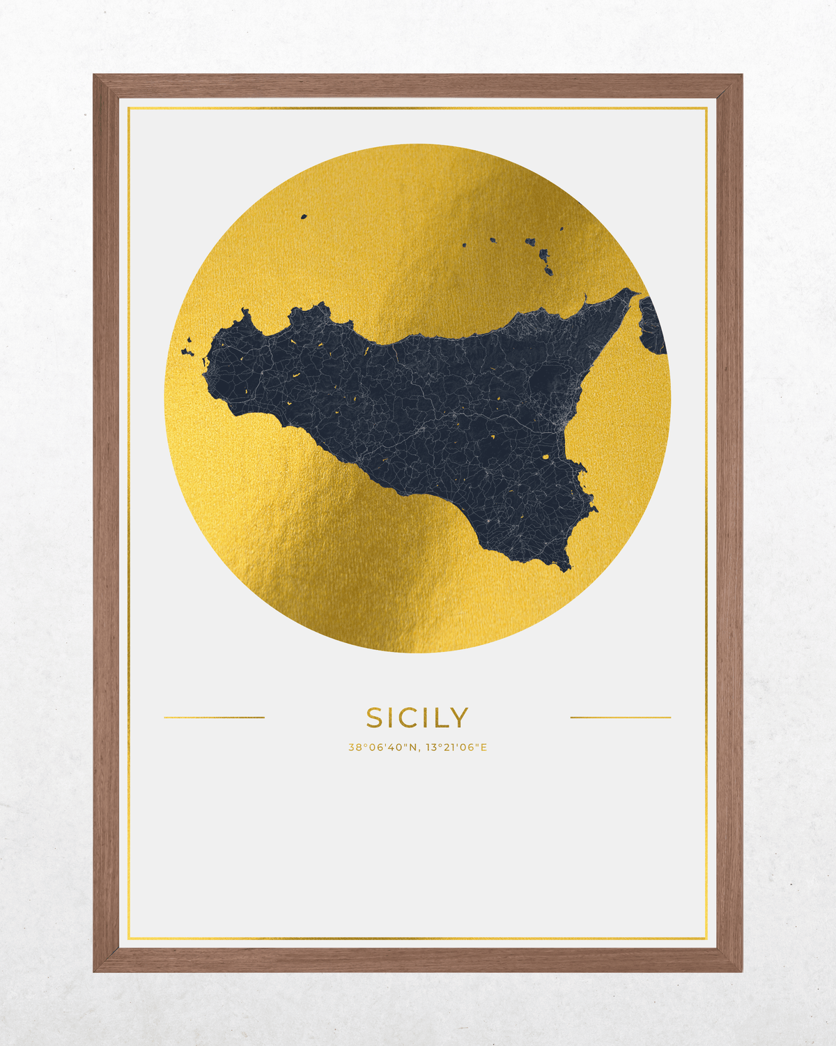 Framed wall art featuring a metallic gold circular map of Sicily with a dark navy blue island silhouette, plus the word 'SICILY' and coordinates below, shown against a light textured wall.