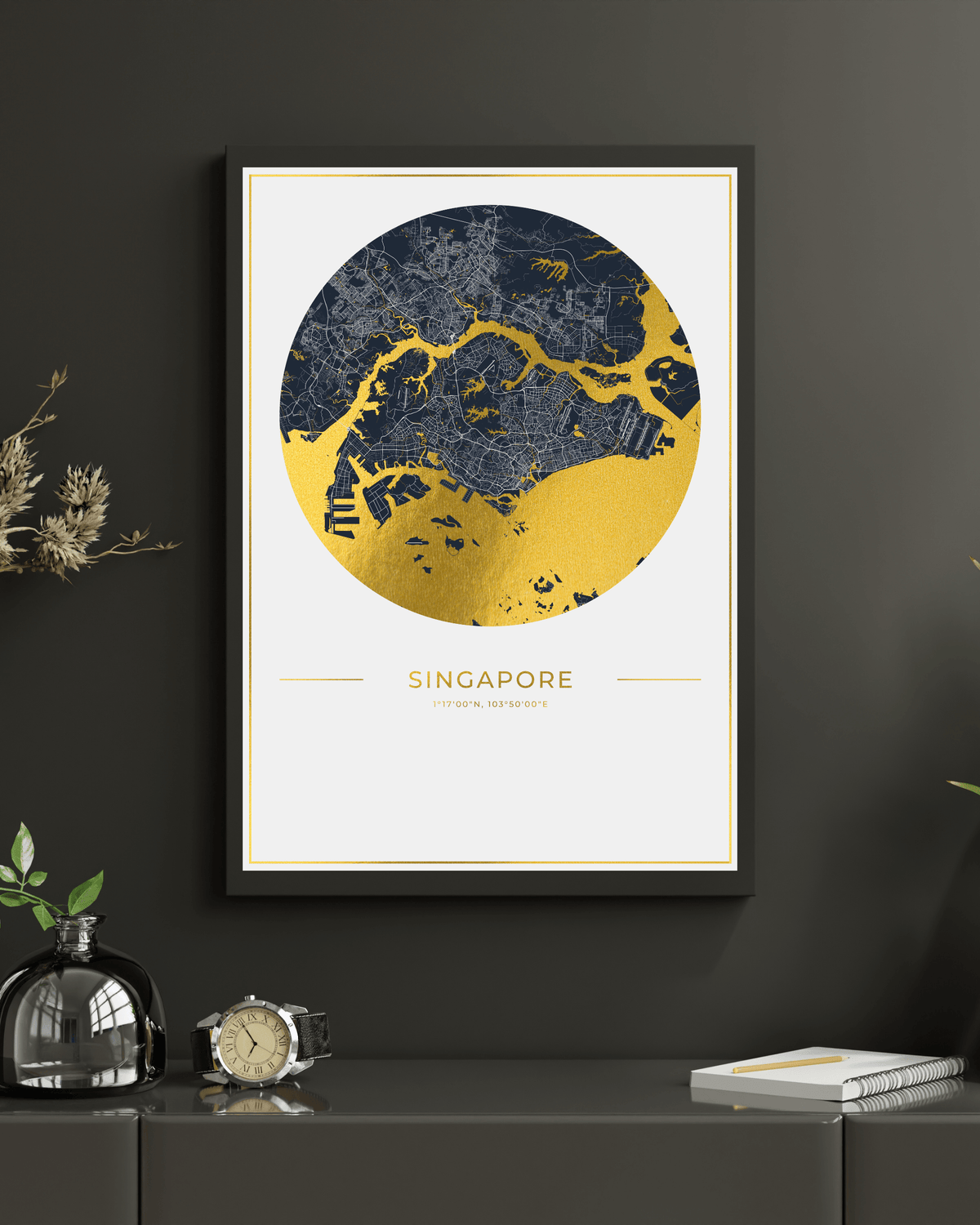 A framed Singapore city map art print with a navy and gold circular design, displayed on a dark gray wall above a console table with decorative objects.