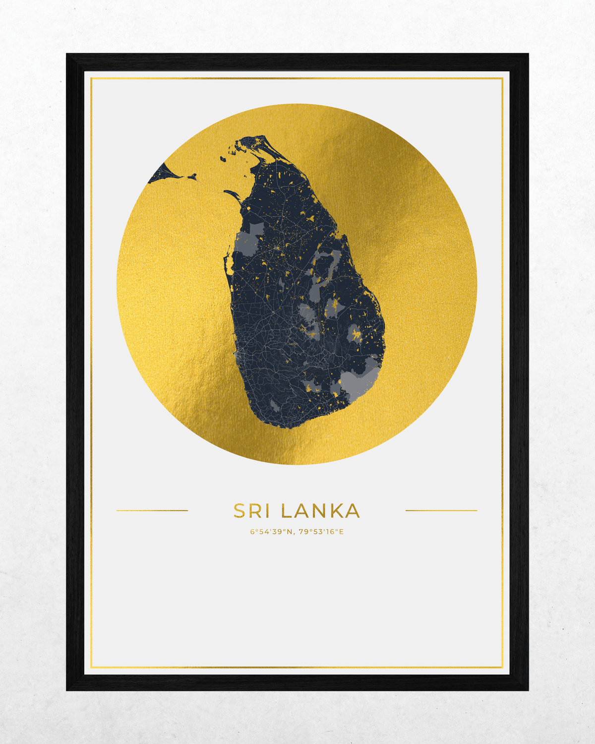 A framed minimalist map print of Sri Lanka, featuring a textured gold circular background with a dark navy map silhouette in the center, and the text 'SRI LANKA' below, presented in a black frame against a light textured wall.