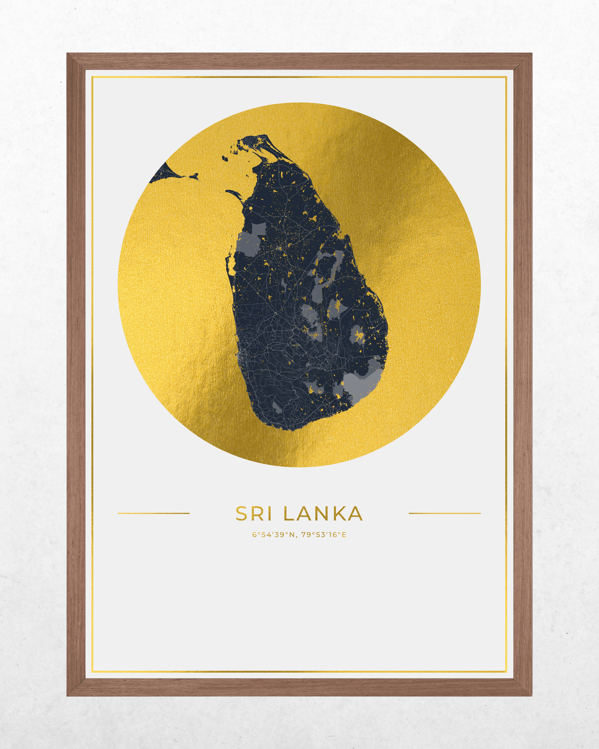 Framed minimalist map print of Sri Lanka, featuring a dark navy silhouette of the island over a large textured gold circle on a white background, with the text 'SRI LANKA' and 'Ceylon Island' below. The print is housed in a brown wood frame.