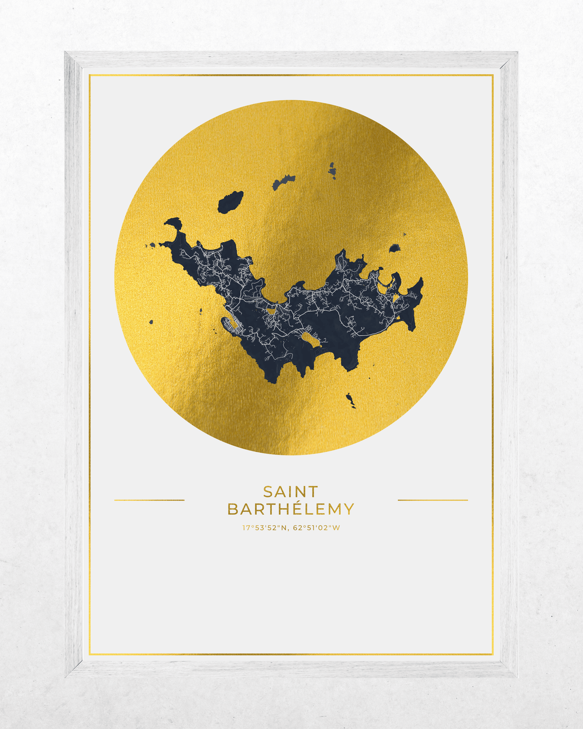 Framed wall art featuring a stylized map of Saint Barthelmy inside a large metallic gold circle, with the destination name printed below on a white background. The print is housed in a white frame and shown against a light textured wall.