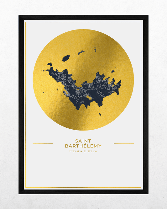 A framed art print featuring a gold foil map of Saint Barthelmy, with a dark navy blue city silhouette overlaid inside a large gold circle. The print is titled 'SAINT BARTHEMY' with coordinates below, set in a black frame against a light textured background.