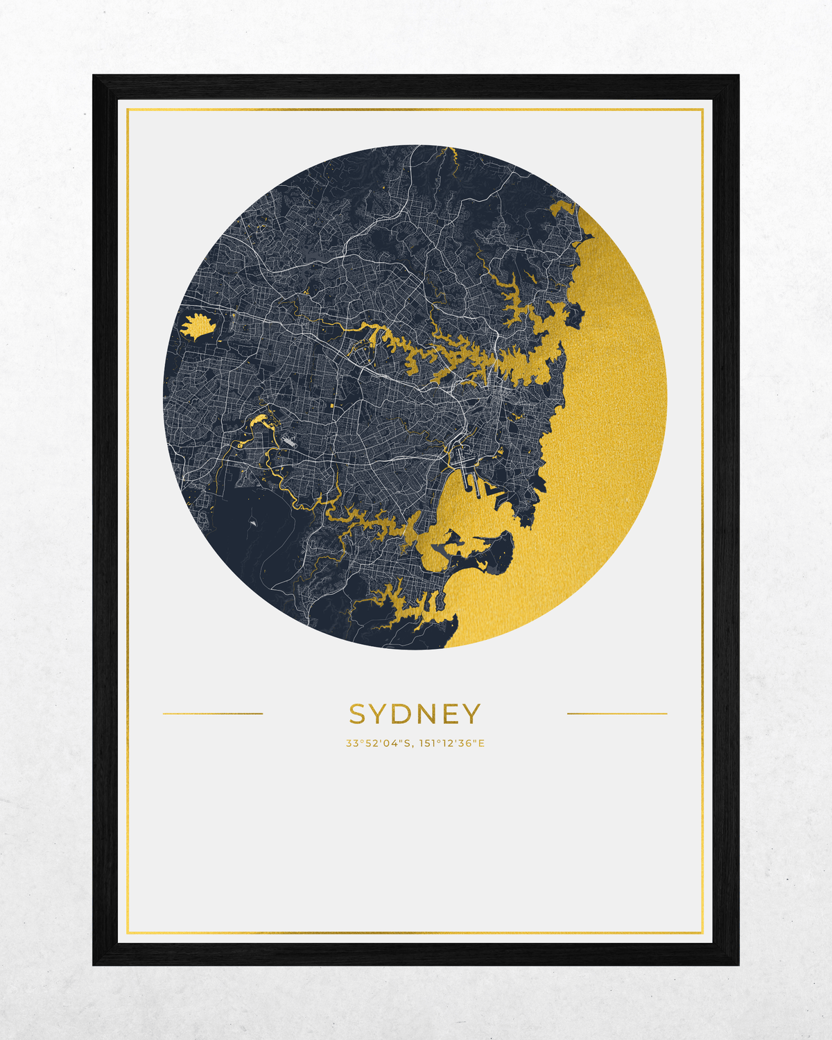 A framed Sydney city map art print featuring a circular map design in dark navy and textured gold on a white background, with the word 'SYDNEY' and smaller text below, shown in a black frame against a light textured wall.
