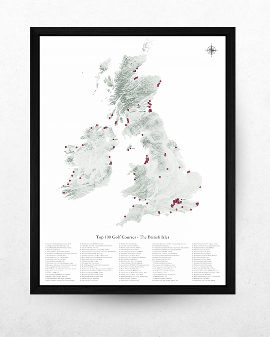 A framed vertical map print of the British Isles showing the top 100 golf courses, with a black frame on a light textured wall.
