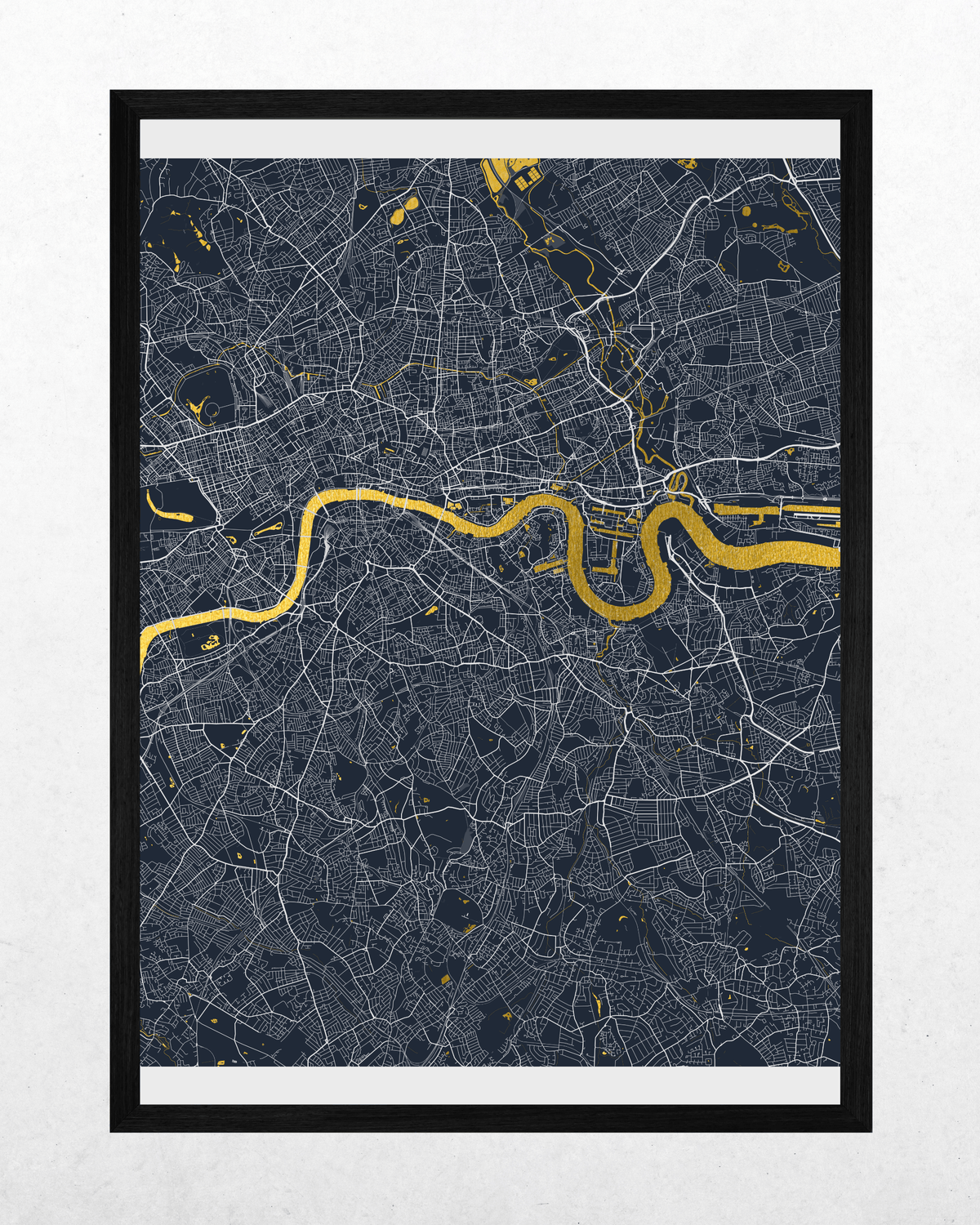 A framed city map print featuring a dark navy background with fine white street lines and a prominent golden-yellow river running horizontally through the center, shown in a black frame against a light textured wall.
