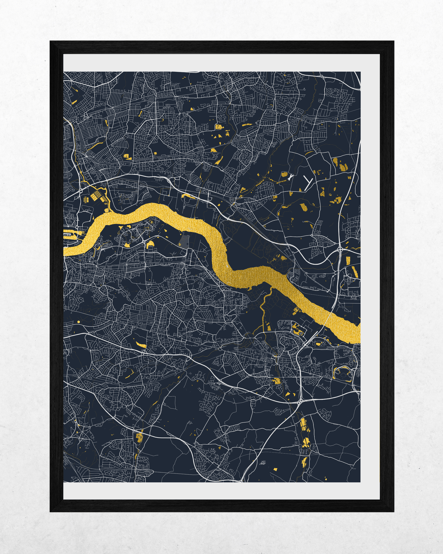 A framed minimalist map print of London, featuring a dark navy background with white street lines and a bright gold river running diagonally through the center, enclosed in a black frame with a white mat.