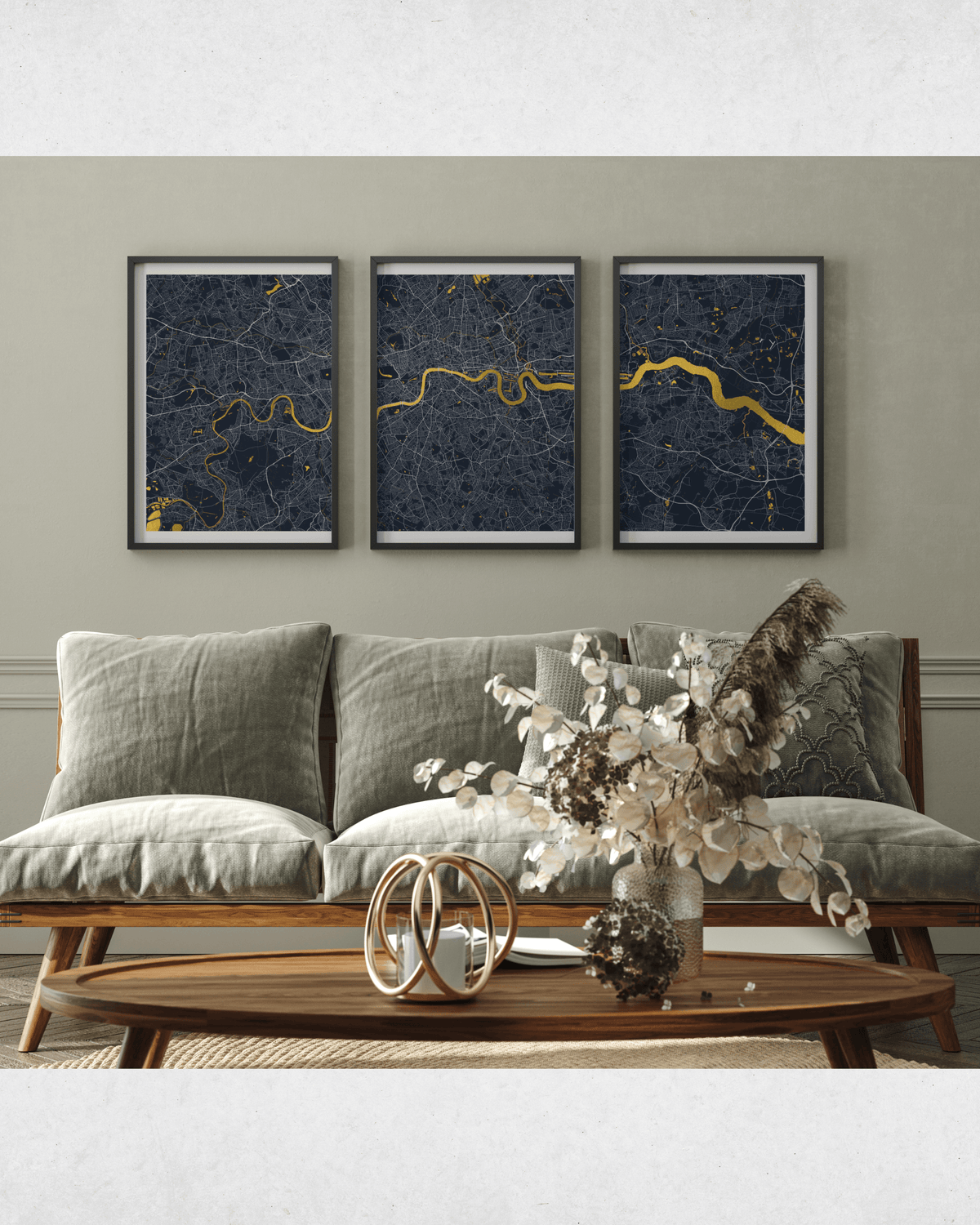 A modern living room setting featuring a three-panel framed wall art set depicting a dark blue and gold map design above a gray sofa.